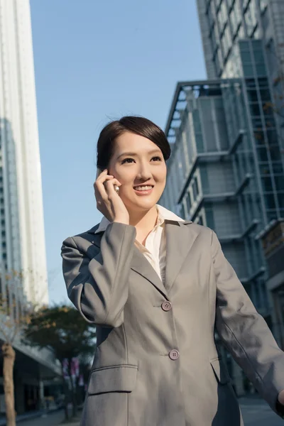 Gelukkig Aziatische zakenvrouw praten over telefoon en lopen op stree — Stockfoto
