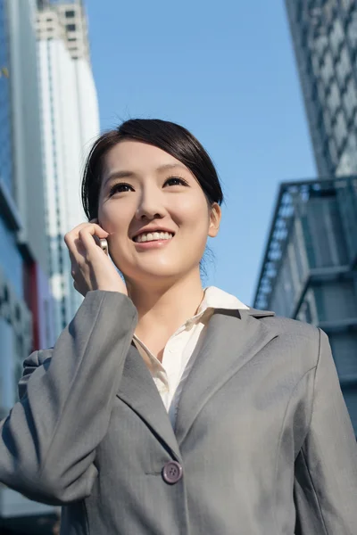 Heureuse femme d'affaires asiatique parlant au téléphone et marchant sur stree — Photo