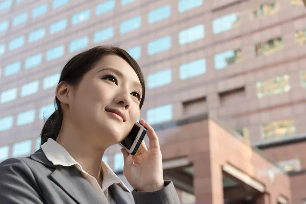 Asian business woman talking on smartphone with copyspace — Stock Photo, Image
