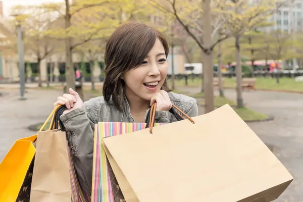 Asyalı kadın yürümek ve alışveriş torbaları tutmak — Stok fotoğraf
