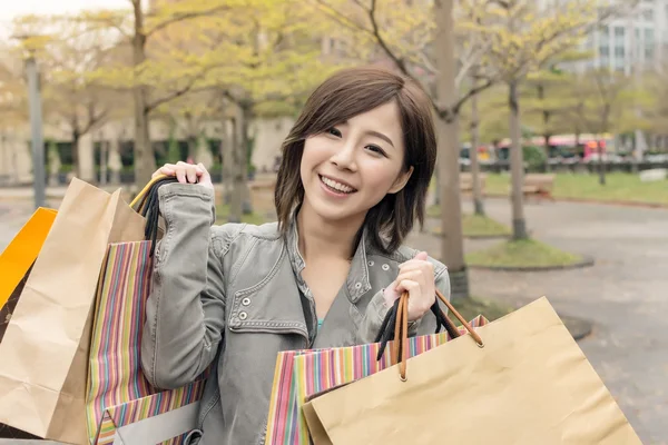 Asiatische Frau geht und hält Einkaufstüten — Stockfoto