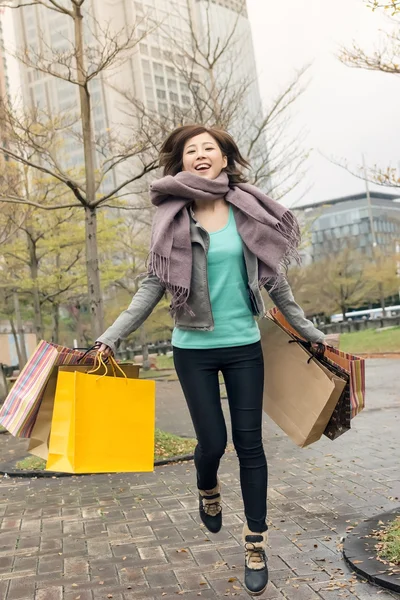 Glada leende shopping kvinna hoppa — Stockfoto