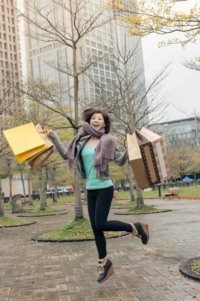Happy smiling shopping woman jumping — Stock Photo, Image