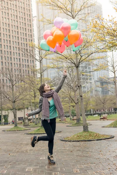 Feliz sonriente mujer asiática sosteniendo globos — Foto de Stock