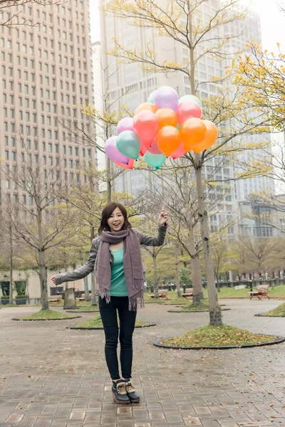 Feliz sonriente mujer asiática sosteniendo globos — Foto de Stock