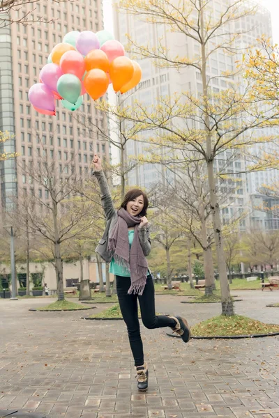 Feliz sonriente mujer asiática sosteniendo globos — Foto de Stock