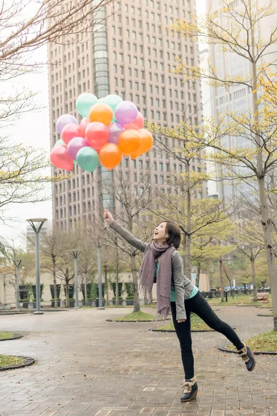 Feliz sonriente mujer asiática sosteniendo globos — Foto de Stock