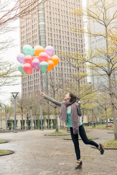 Feliz sonriente mujer asiática sosteniendo globos — Foto de Stock