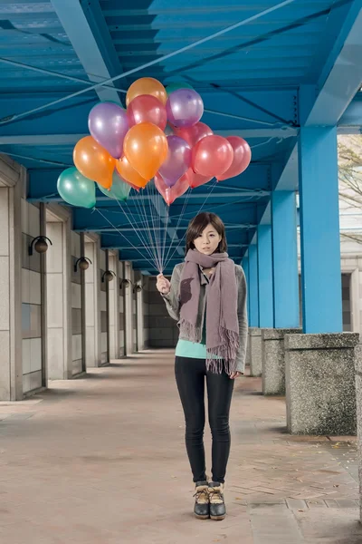 Elegante asiático belleza celebración globos bajo puente — Foto de Stock