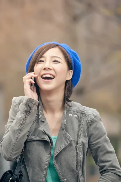 Veselá asijské dáma mluví na ulici, v parku na mobil, — Stock fotografie