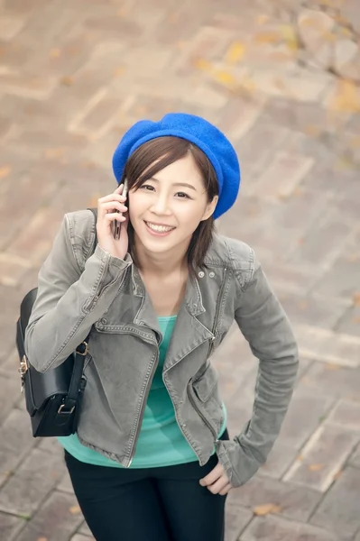 Cheerful Asian lady talking on cellphone at street in the park, — Stock Photo, Image