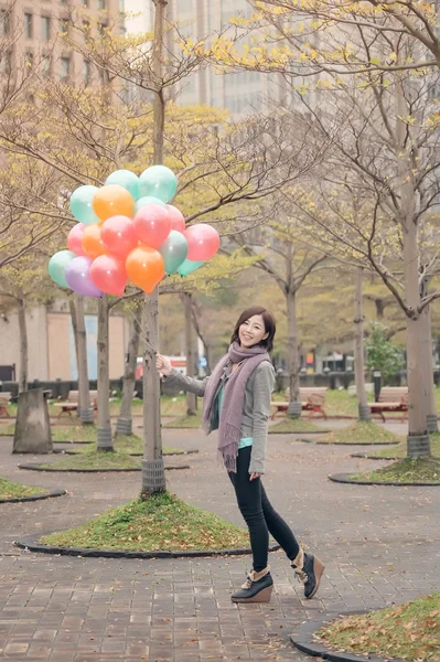 Mujer joven jugando y sosteniendo globos —  Fotos de Stock