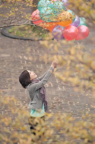 Молода жінка грає і тримає повітряні кулі — стокове фото