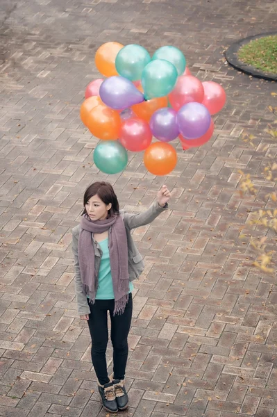 Junge Frau spielt und hält Luftballons — Stockfoto