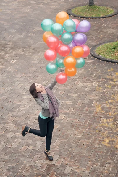 Jeune femme jouant et tenant des ballons — Photo