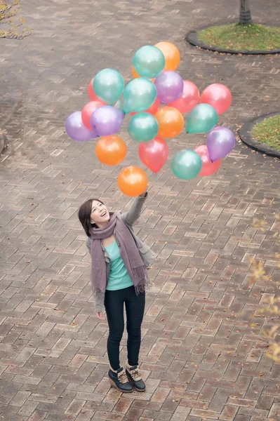 Giovane donna che gioca e tiene palloncini — Foto Stock