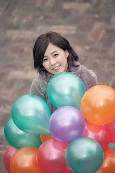 Jonge vrouw spelen en houden van ballonnen — Stockfoto