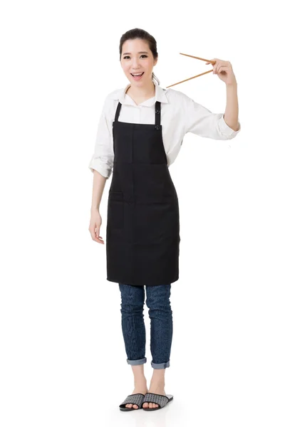 Молодая азиатская домохозяйка держит палочки для еды — стоковое фото