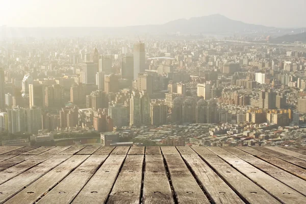 Puesta de sol de la ciudad con suelo de madera — Foto de Stock