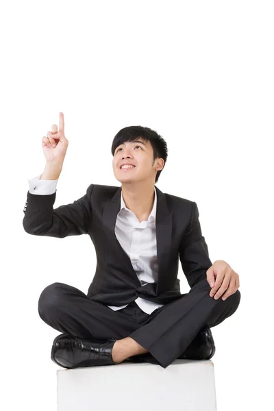 Азиатский бизнесмен сидит и показывает вверх — стоковое фото