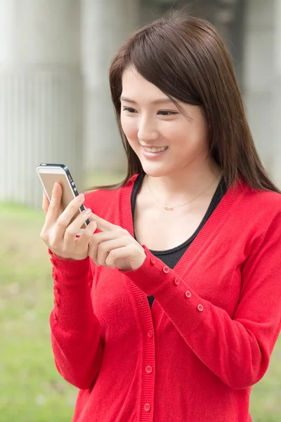 Aantrekkelijke jonge Aziatische vrouw met behulp van smartphone — Stockfoto