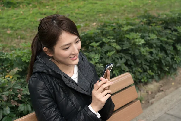 Attrayant jeune asiatique femme en utilisant smartphone — Photo