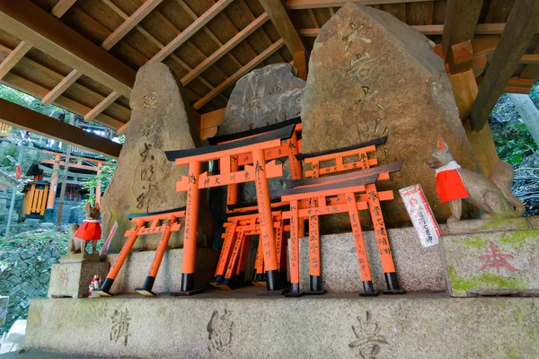 Statues de renard en pierre et de nombreux petits torii . — Photo