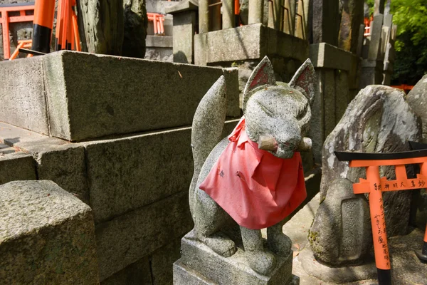 Estátuas de raposa de pedra e muitos pequenos torii . — Fotografia de Stock