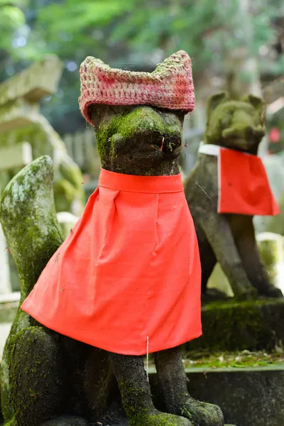 Stone fox statue with red cap. — Stock Photo, Image