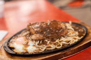 Kadınlar sokakta Tayvan usulü gece bifteği yiyorlar.