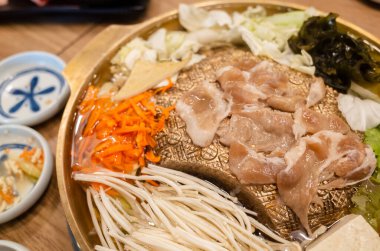 Bir restoranda bakır ızgara tepsisi üzerinde Kore barbeküsü