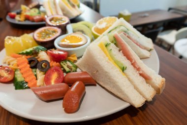 Sabah bir tabakta ekmek, sebze ve meyve kahvaltısı.