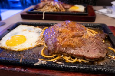 Tayvan 'da ucuz bir et lokantasında demir bir tabakta lezzetli bir biftek.