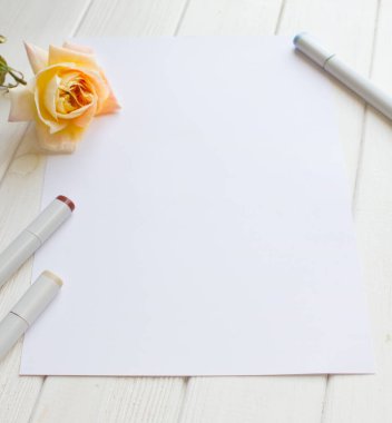 Tek gül ve çizim malzemesi olan A4 kağıdı için maket