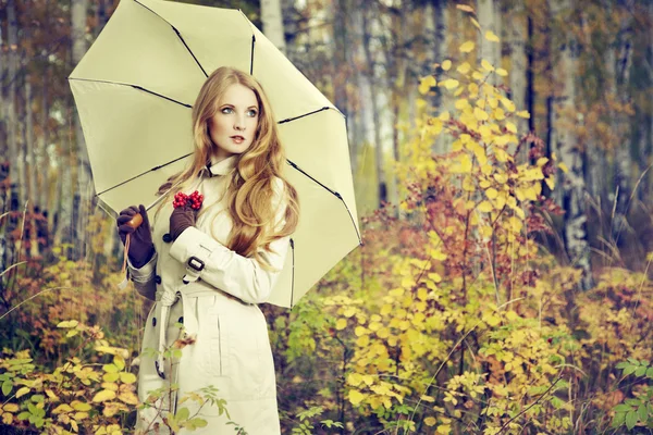 Fashion portrait of a beautiful young woman in autumn forest — Stock Photo, Image