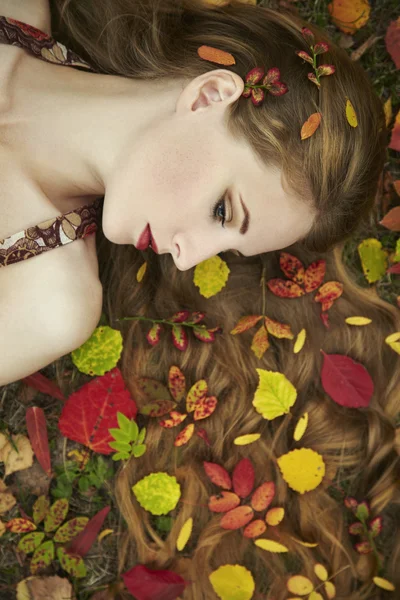 Fashion portrait of a beautiful young woman in autumn garden — Stock Photo, Image