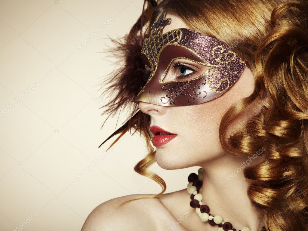 Beautiful young woman in brown mysterious venetian mask