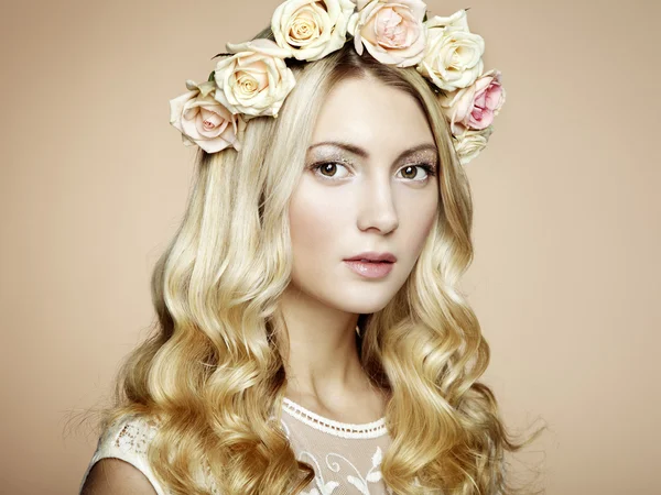Retrato de uma bela mulher loira com flores em seu cabelo — Fotografia de Stock