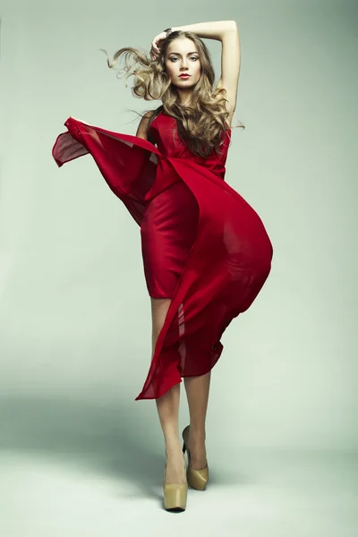 Kırmızı elbiseli genç muhteşem kadın moda fotoğrafı