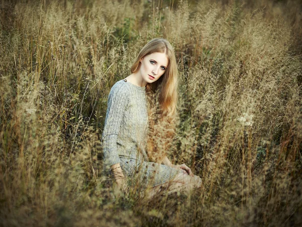 Portrait of beautiful woman on autumn field — Stock Photo, Image