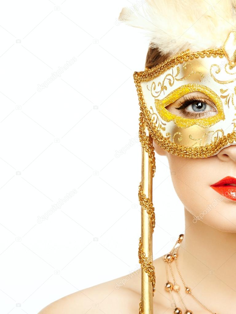 Beautiful young woman in mysterious golden Venetian mask