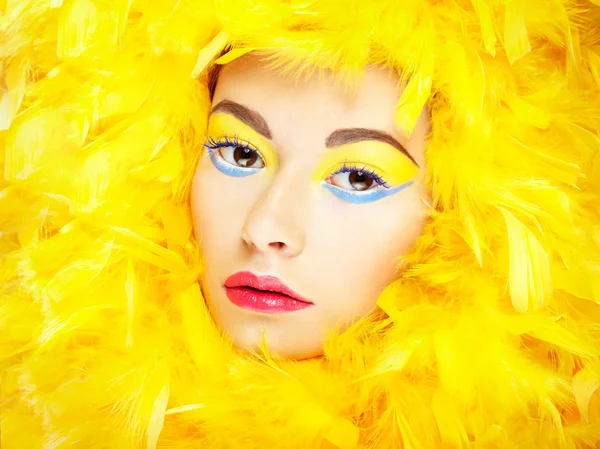 Porträt eines schönen Mädchens mit gelben Federn. Perfektes Make-up — Stockfoto