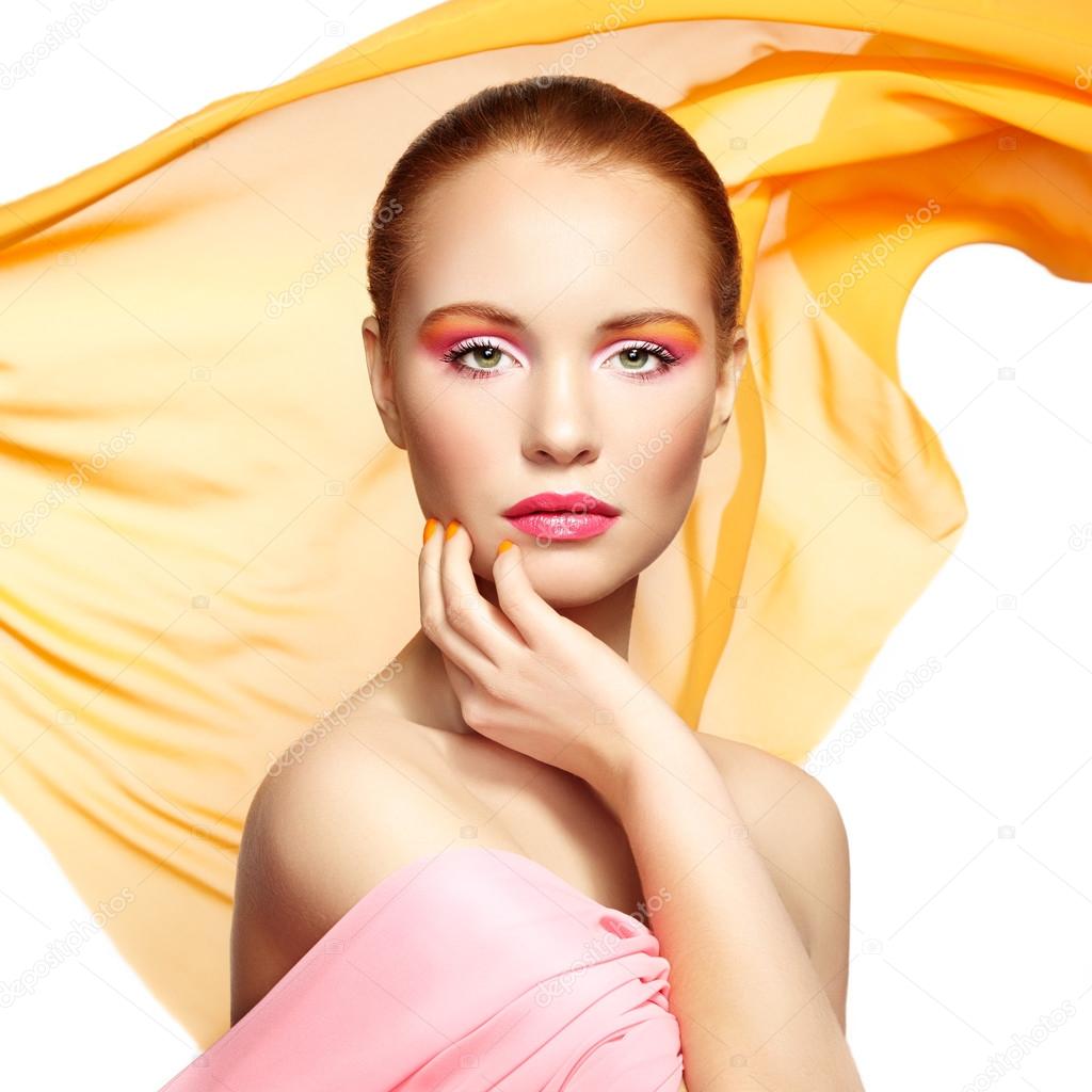 Portrait of young beautiful woman against flying fabric. Beauty 
