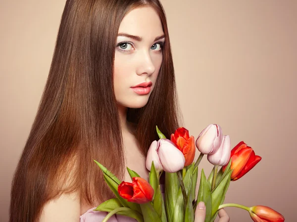 Portret van mooie donkerharige vrouw met bloemen — Stockfoto