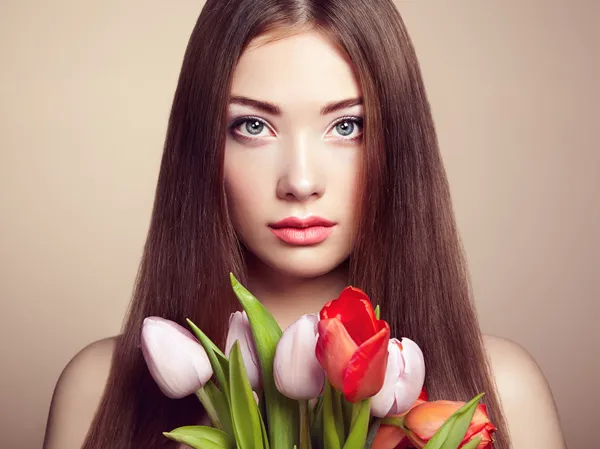 Portrait of beautiful dark-haired woman with flowers — Stock Photo, Image