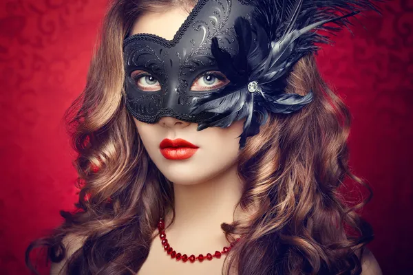 Mooie jonge vrouw in zwarte mysterieuze Venetiaanse masker — Stockfoto