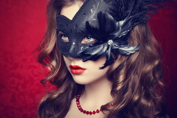 Mooie jonge vrouw in zwarte mysterieuze Venetiaanse masker — Stockfoto
