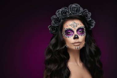 Mor arka planda şeker kafatası makyajı olan bir kadının portresi. Cadılar Bayramı kostümü ve makyaj. Calavera Catrina 'nın Portresi