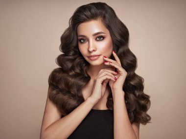 Mükemmel makyajlı esmer kız. Uzun kıvırcık saçlı, gülümseyen güzel model kadın. Bakım ve güzellik ürünleri. Kırmızı tırnaklı manikür.