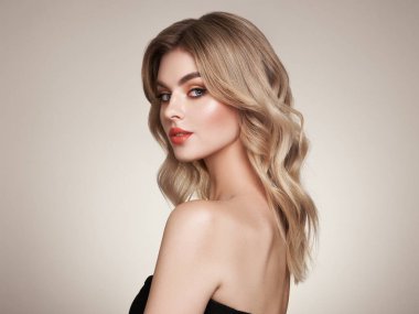 Parlak dalgalı sarı saçlı güzel bir genç kadın. Sağlıklı ciltli bir model, yakın portre. Kozmetik, güzellik ve kaplıca